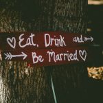 red and white eat, drink, and be married signage near brown tree